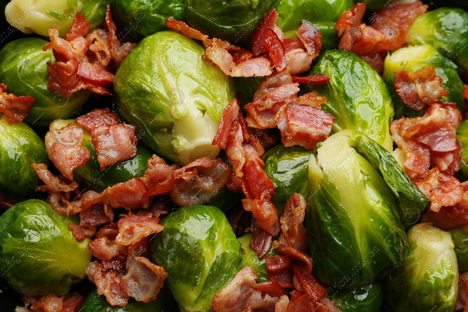 Photo of Tasty cooked Brussels sprouts with bacon as background, top view