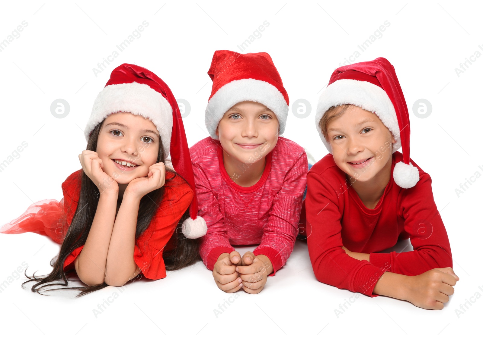 Photo of Cute little children in Santa hats on white background. Christmas celebration