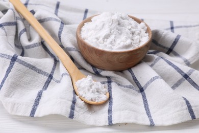 Bowl and spoon of starch on white wooden table