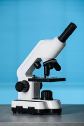 Modern medical microscope on grey table indoors