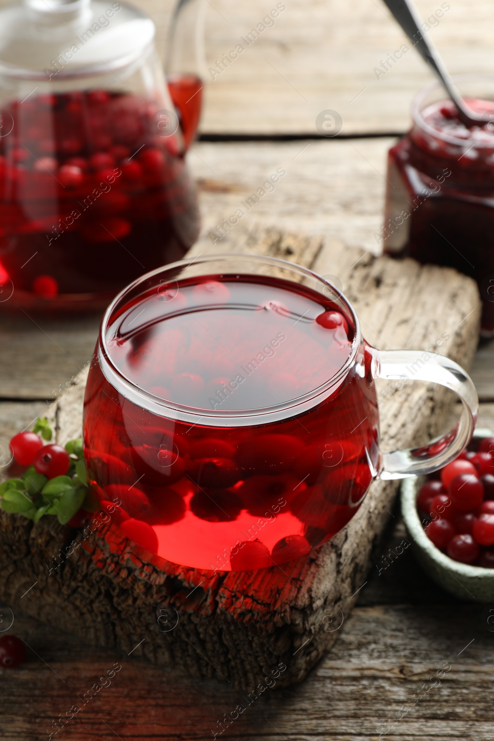 Photo of Delicious cranberry tea and berries on wooden table