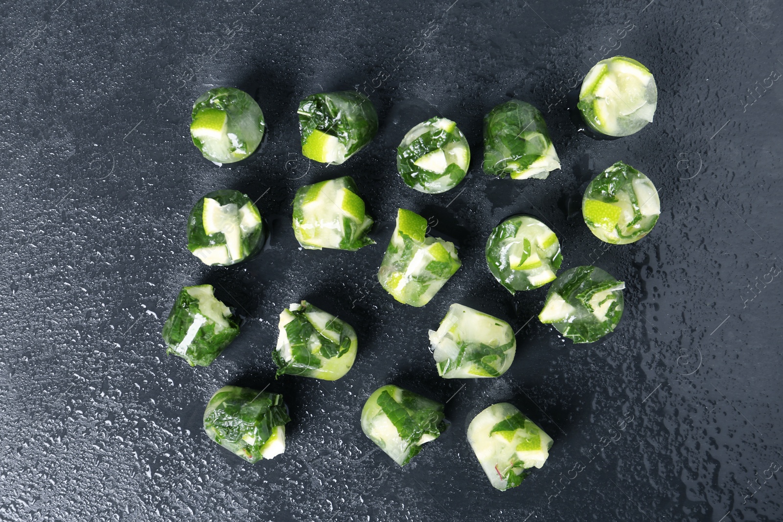 Photo of Lime and mint ice cubes on dark background, flat lay