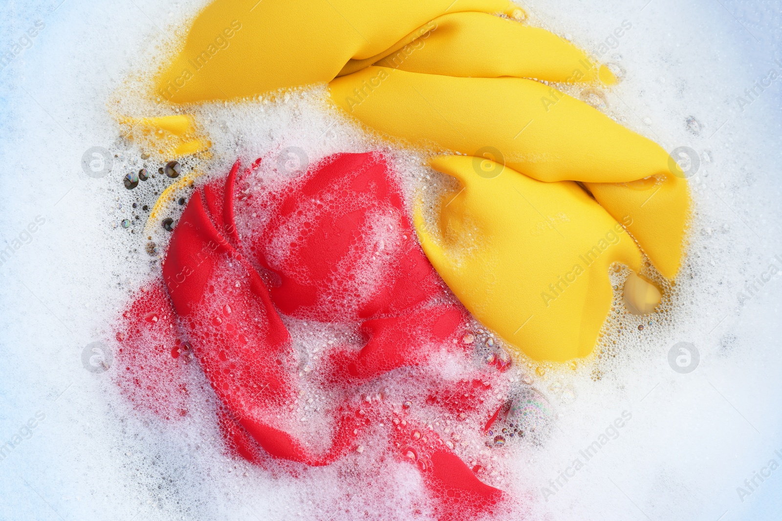 Photo of Color clothing in suds, top view. Hand washing laundry