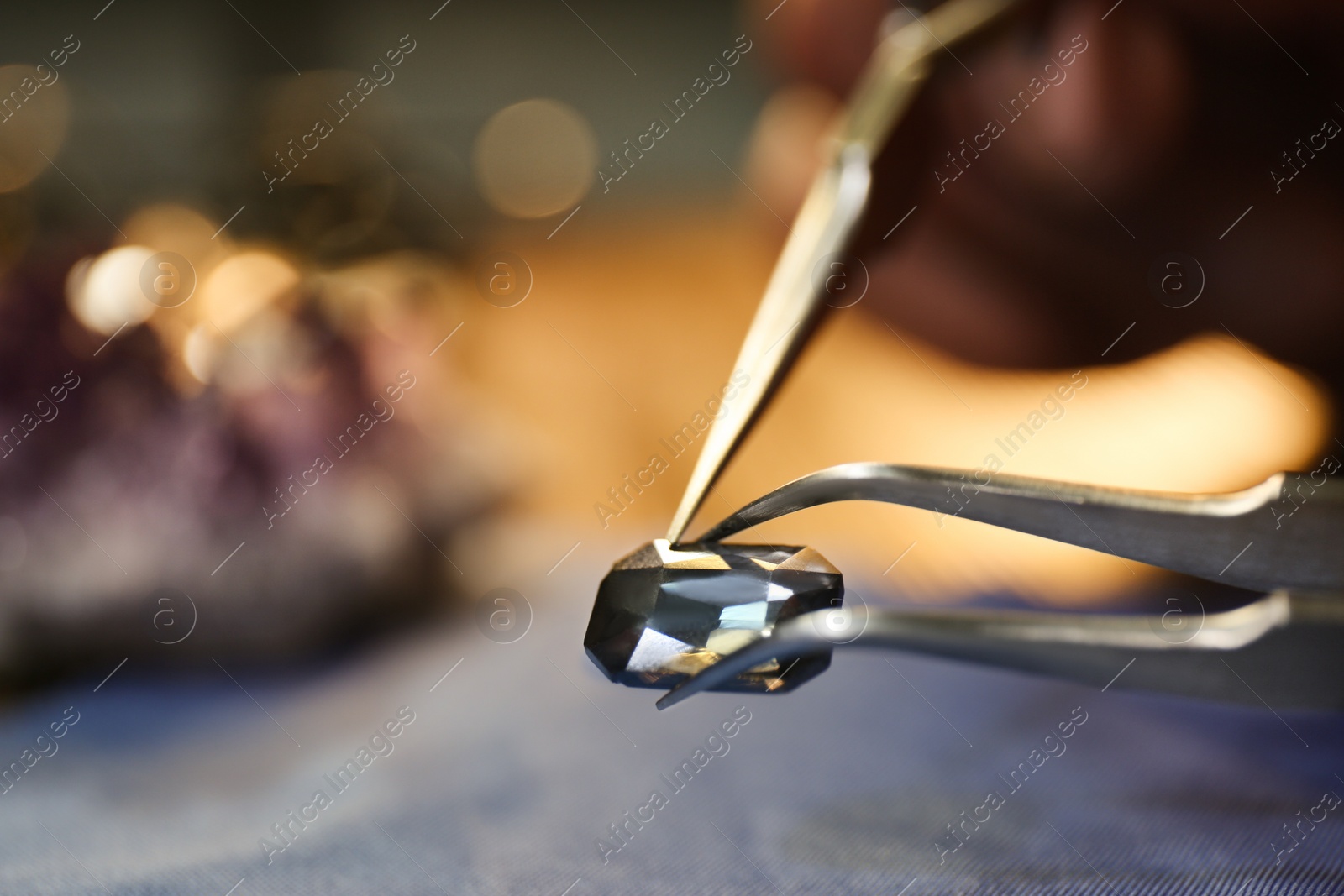 Photo of Beautiful gemstone in jeweler's workshop, closeup. Space for text