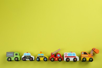 Photo of Different toy cars for children on yellow background, flat lay. Space for text