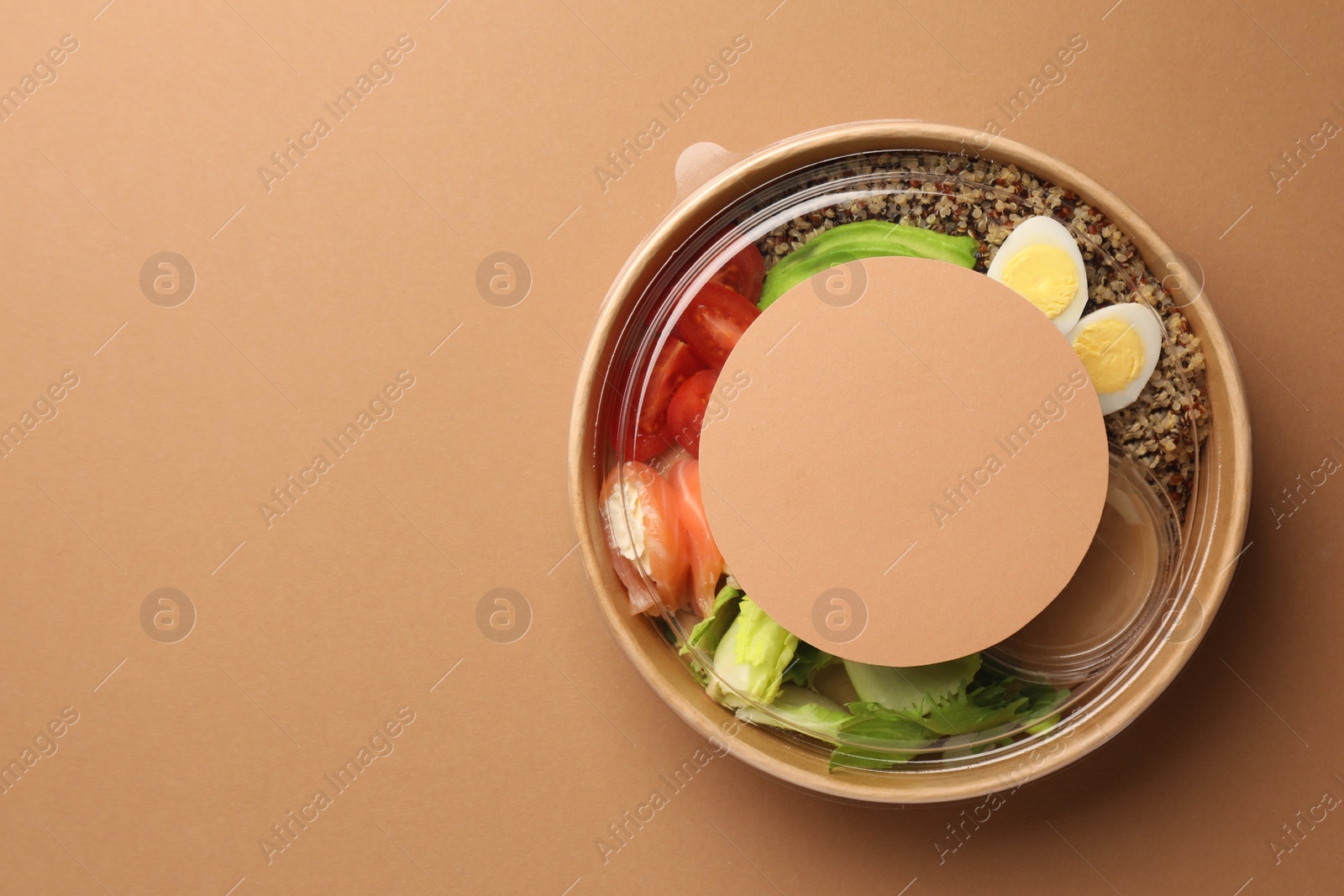 Photo of Tasty food in container on beige background, top view. Space for text