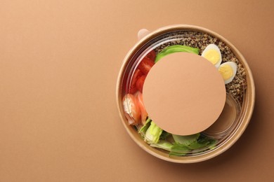 Tasty food in container on beige background, top view. Space for text