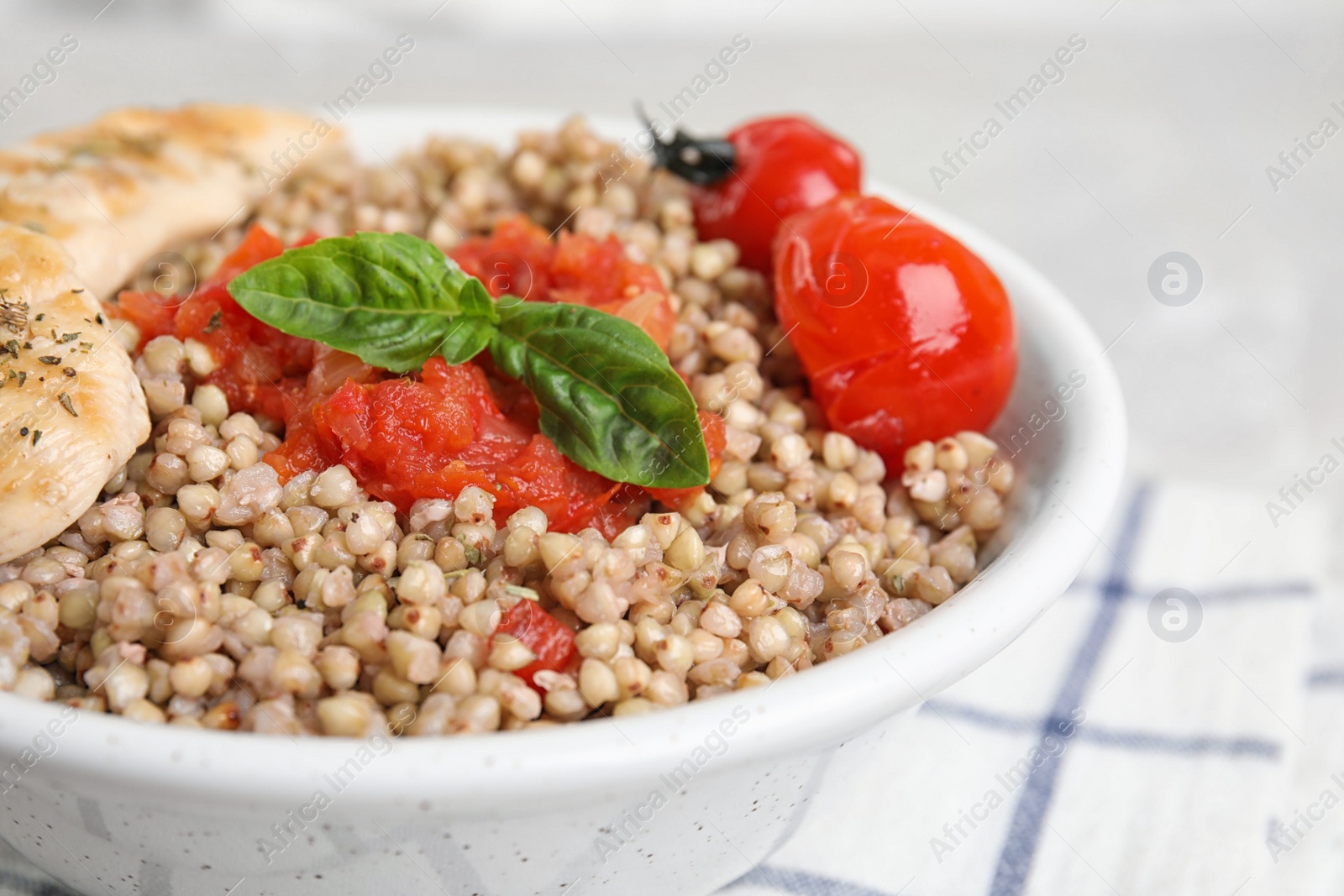 Photo of Bowl with tasty buckwheat porridge and meat, closeup