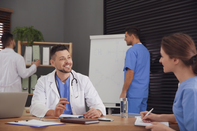 Photo of Team of professional doctors having meeting in office