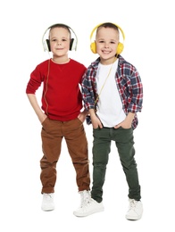 Photo of Full length portrait of cute twin brothers with headphones on white background