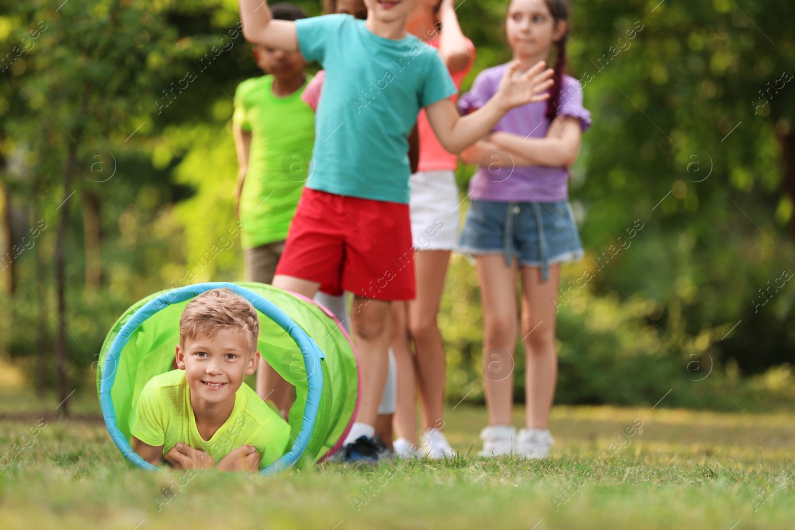 Photo of Cute little child playing with friends in park, space for text