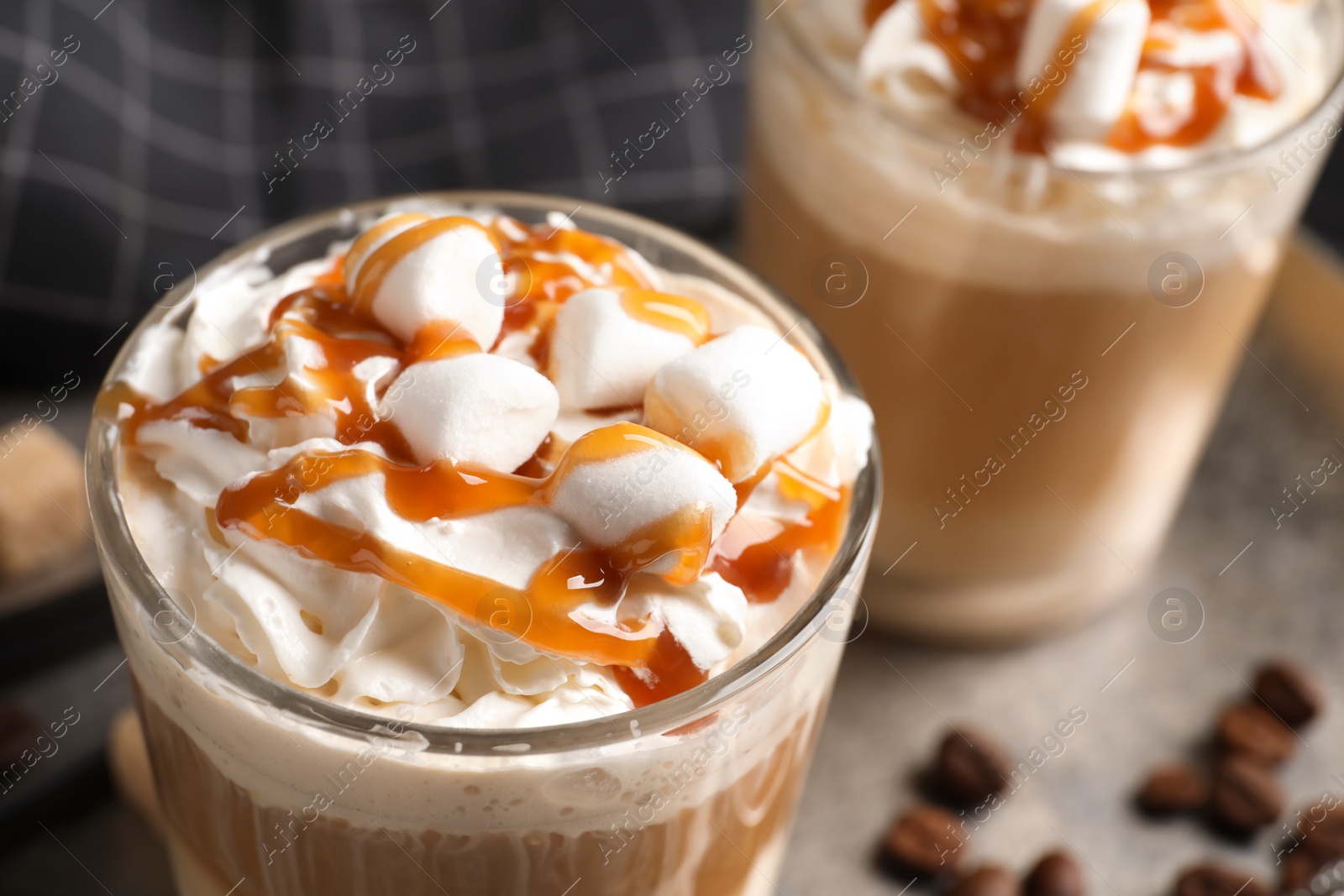 Photo of Glass with delicious caramel frappe on tray, closeup