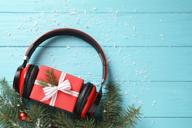 Flat lay composition with headphones on blue wooden background, space for text. Christmas music concept