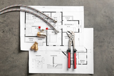 Photo of Flat lay composition with house plan and plumber's items on grey background