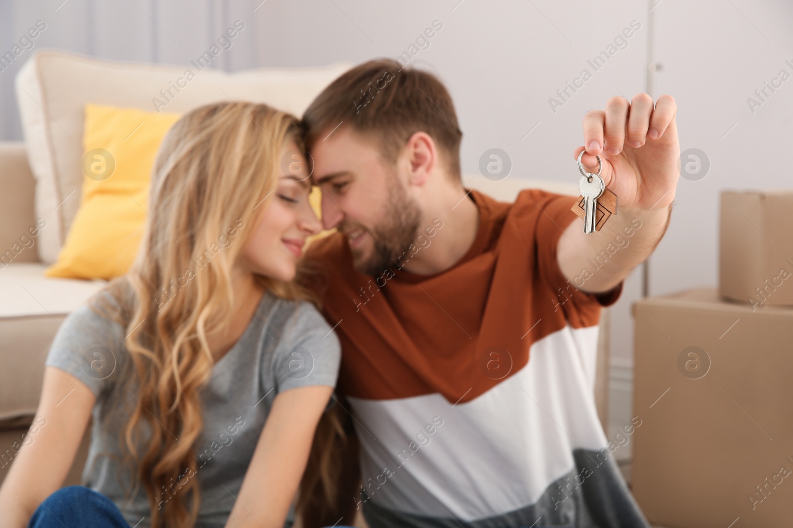 Photo of Happy young couple with key from their new house indoors, closeup