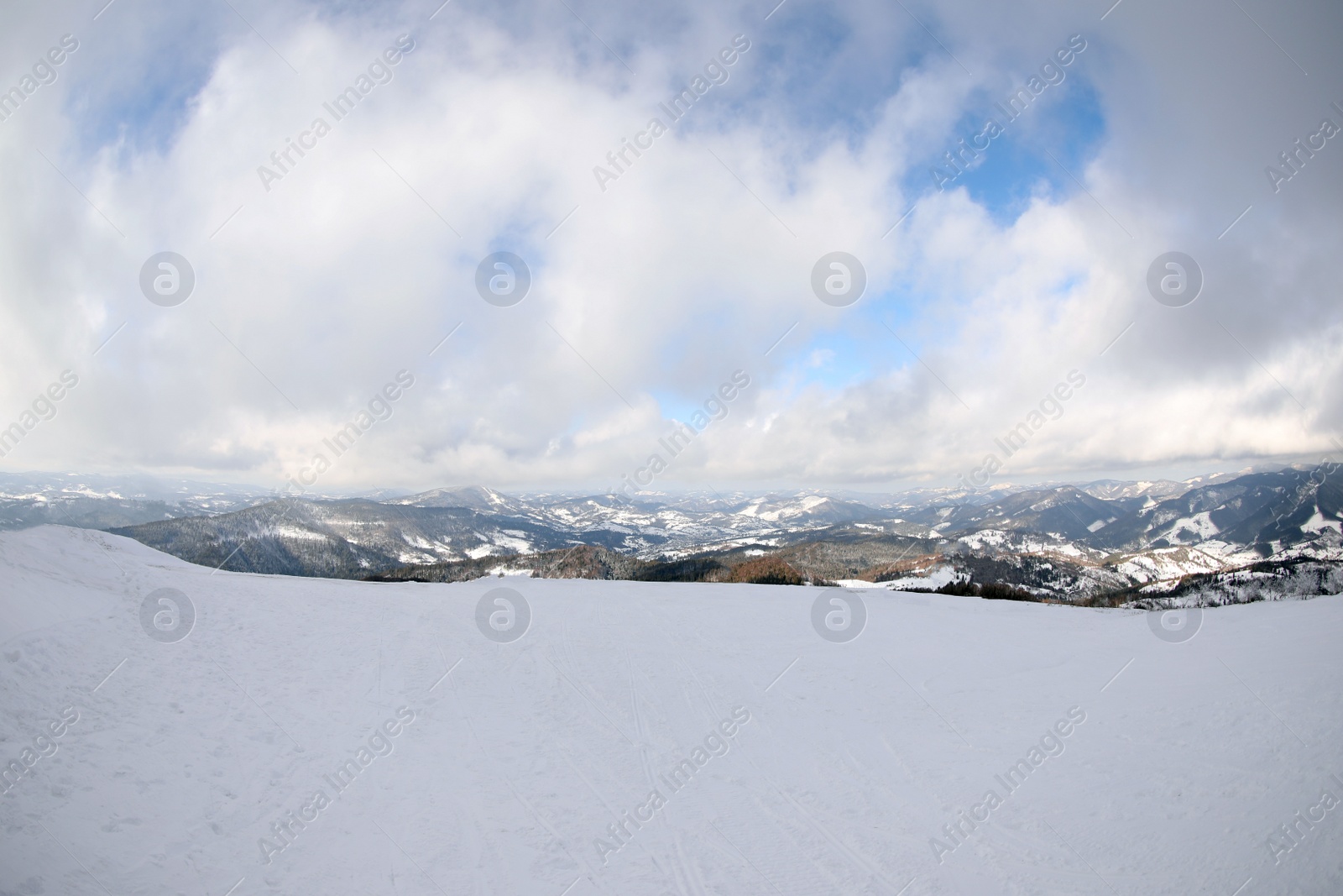 Photo of Picturesque mountain landscape with snowy hills under cloudy sky