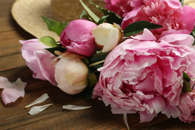 Photo of Beautiful fragrant peonies on wooden table, closeup