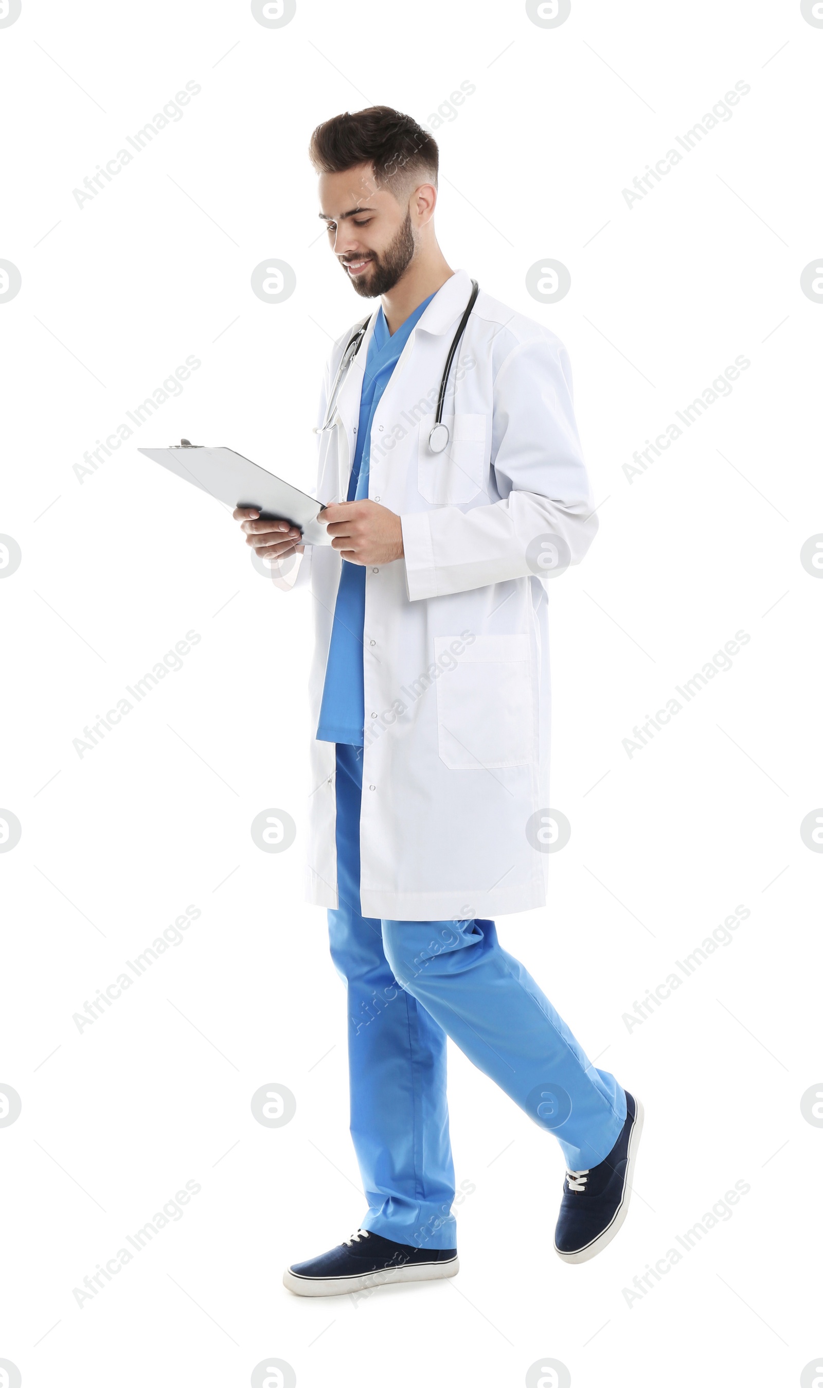 Photo of Young male doctor in uniform with clipboard isolated on white