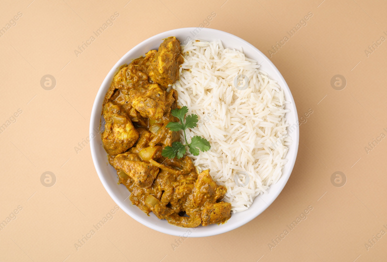 Photo of Delicious chicken curry with rice on beige background, top view