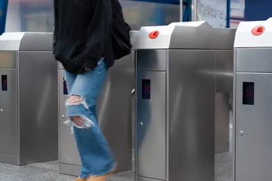 Photo of Teenager passing turnstile, closeup view. Fare collection system