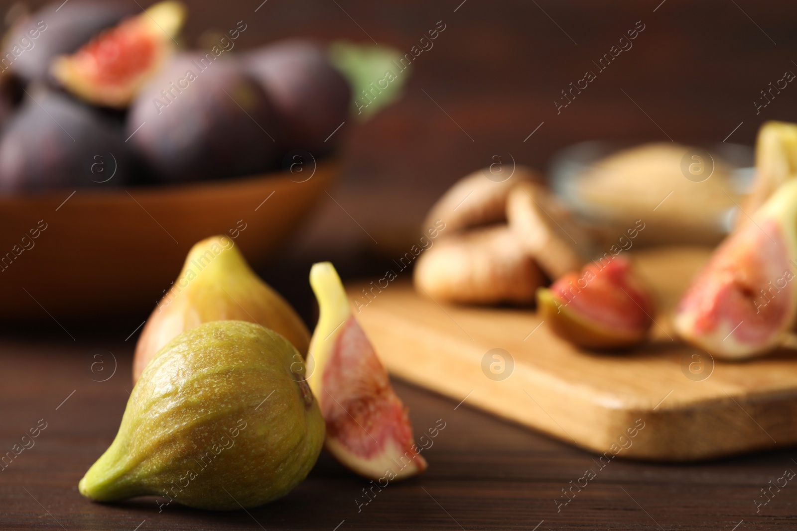Photo of Tasty raw figs on brown wooden table, closeup
