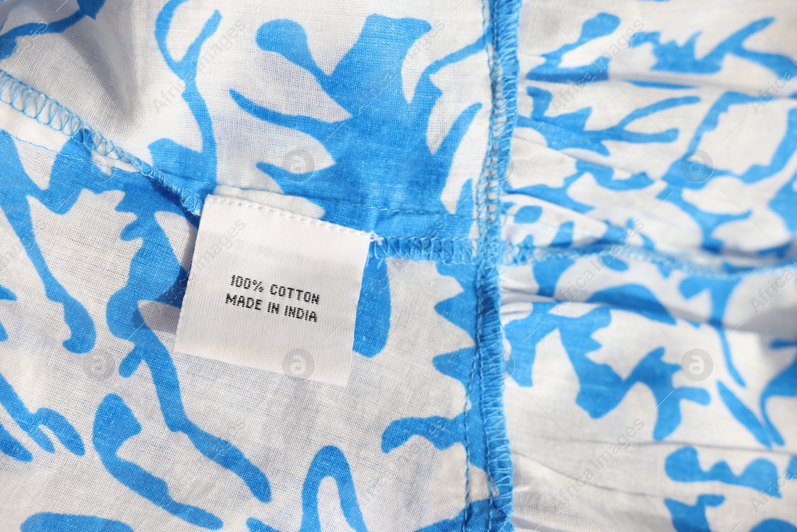 Photo of Clothing label on color garment, closeup view