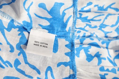 Photo of Clothing label on color garment, closeup view