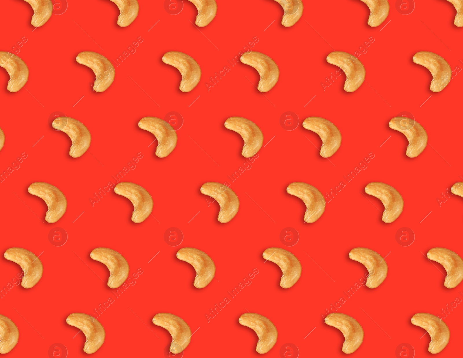 Image of Many tasty cashew nuts on red background, flat lay