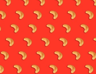 Many tasty cashew nuts on red background, flat lay