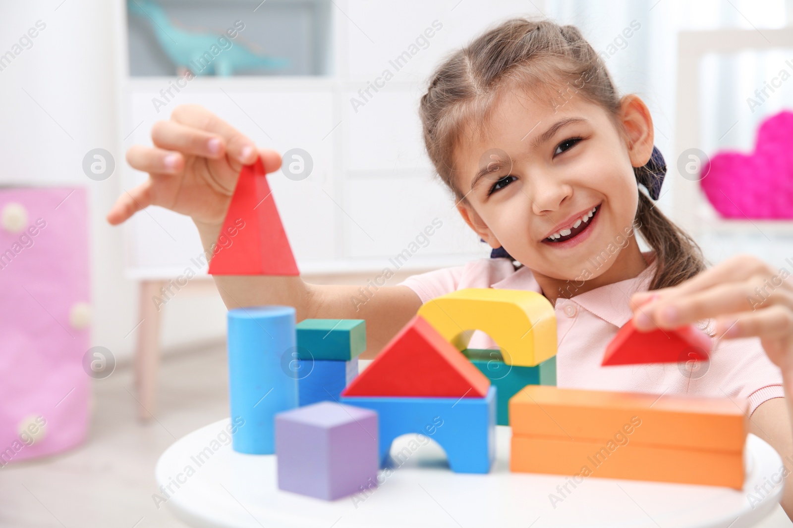 Photo of Cute child playing with colorful blocks at home