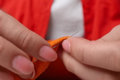 Photo of Woman sewing cloth with needle, closeup view