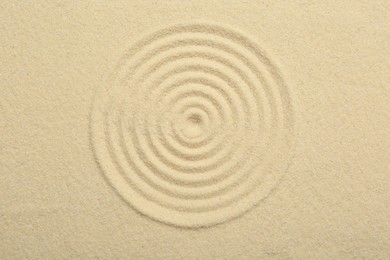 Photo of Zen rock garden. Circle pattern on beige sand, top view