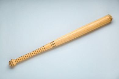 Photo of Wooden baseball bat on light grey background, top view. Sports equipment