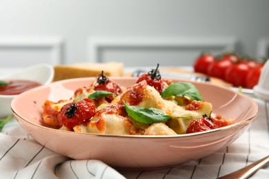 Photo of Tasty ravioli with tomato sauce served on table, closeup
