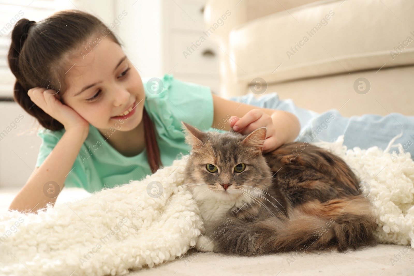 Photo of Cute little girl with cat lying on carpet at home. First pet