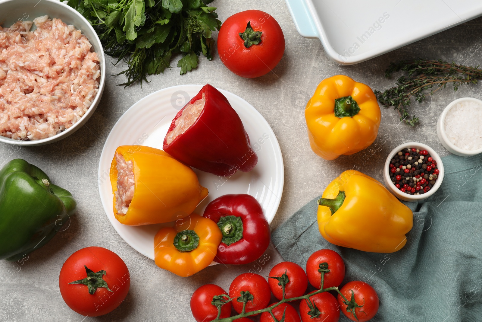 Photo of Raw stuffed peppers, ground meat and ingredients on grey table, flat lay