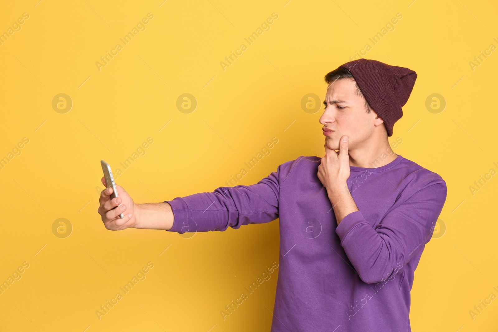 Photo of Young handsome man taking selfie against color background