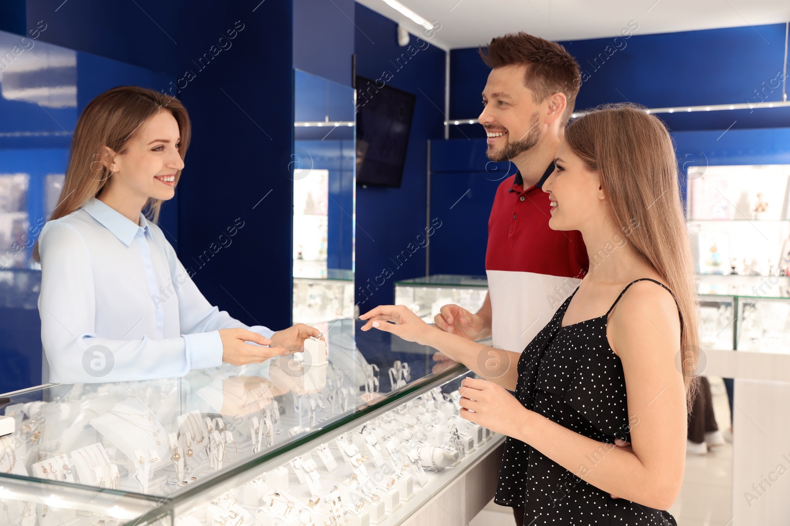 Photo of Couple choosing engagement ring in jewelry store