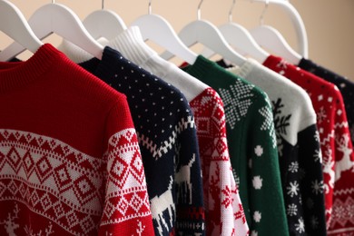 Rack with different Christmas sweaters, closeup view