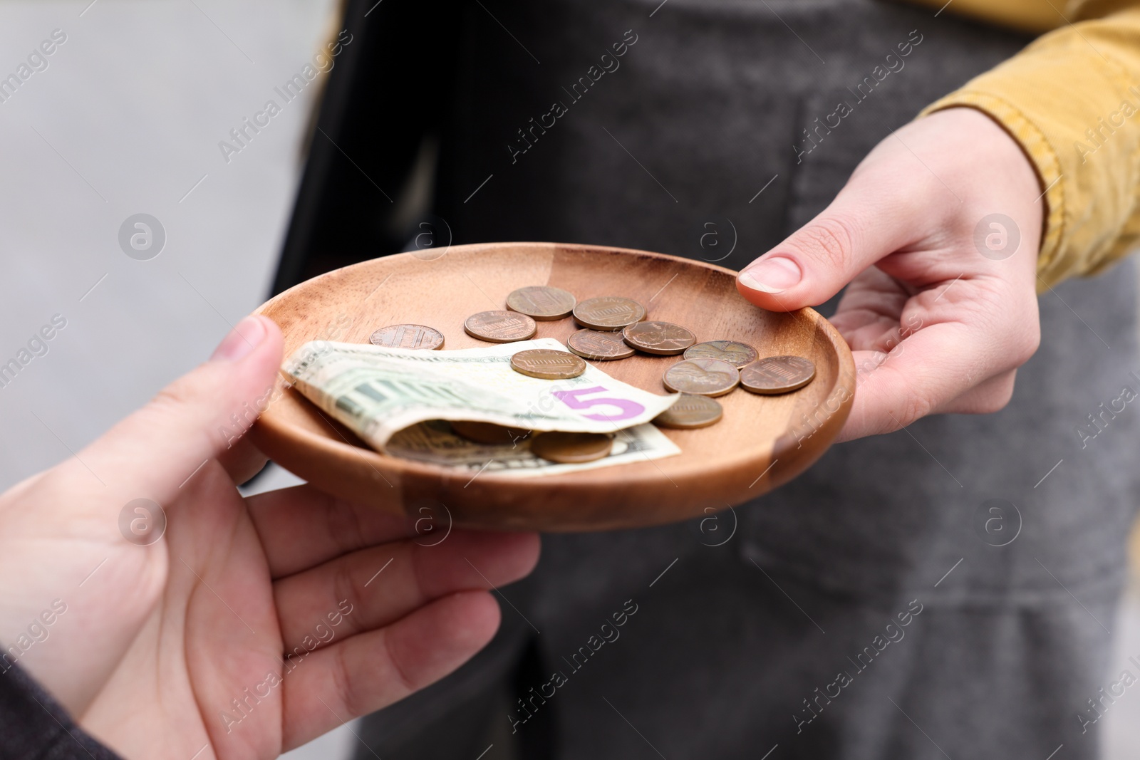 Photo of Client giving tips to waitress in outdoor cafe, closeup