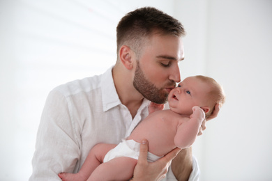 Photo of Father with his newborn son on light background