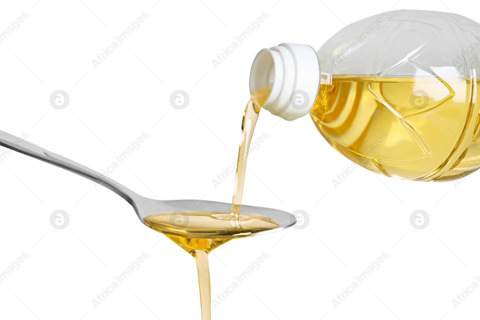 Photo of Pouring cooking oil from bottle into spoon on white background, closeup