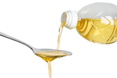 Pouring cooking oil from bottle into spoon on white background, closeup