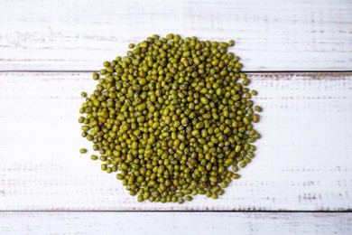 Photo of Pile of green mung beans on white wooden table, top view