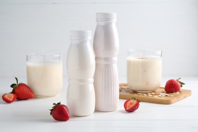 Tasty yogurt, oats and strawberries on white wooden table