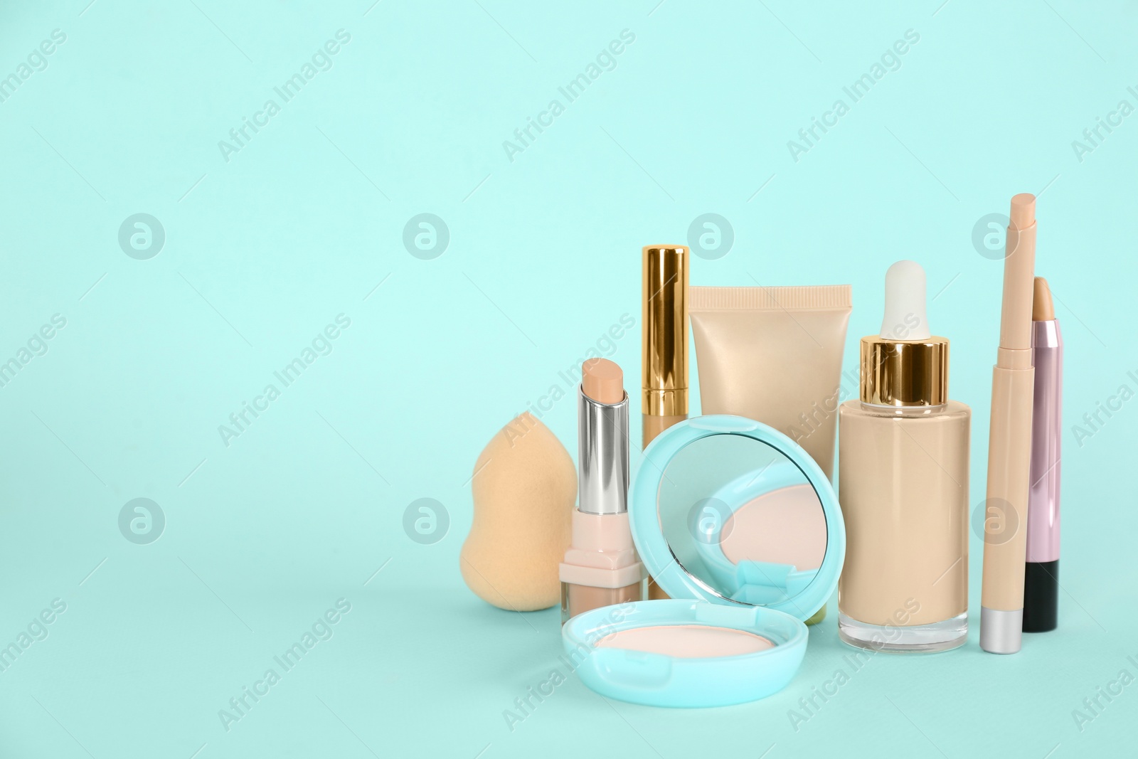 Photo of Foundation makeup products on turquoise background, space for text. Decorative cosmetics