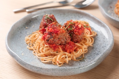 Delicious pasta with meatballs and tomato sauce on table