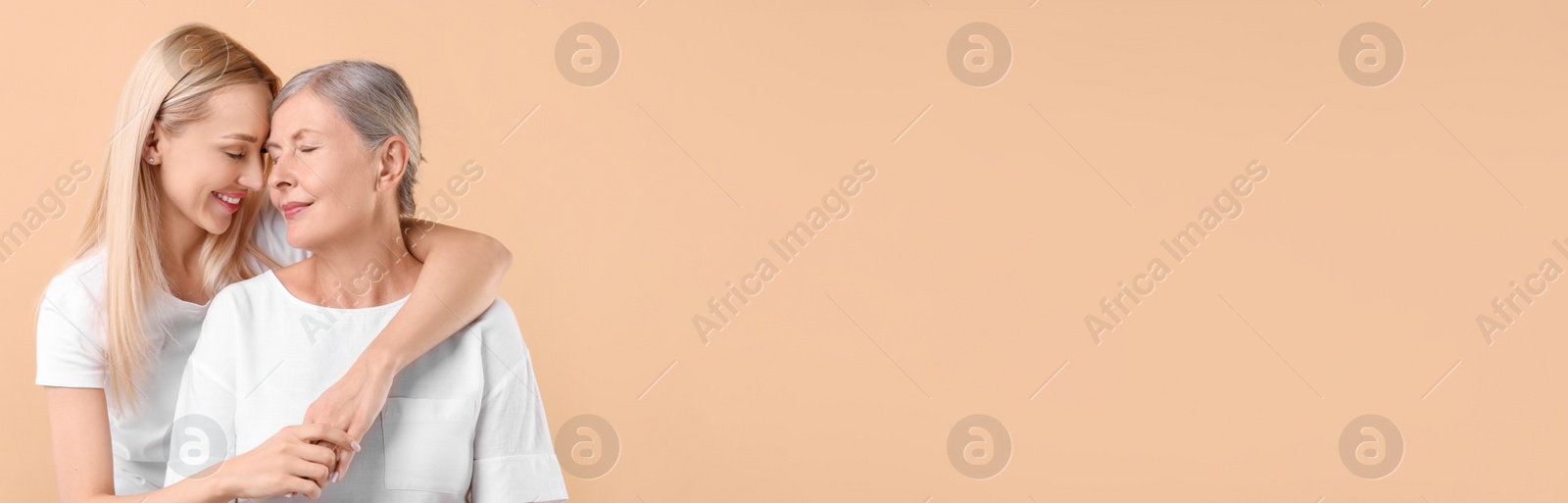 Image of Happy mother and daughter on beige background, space for text. Banner design