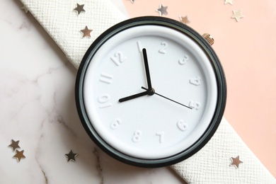 Photo of Stylish wrist watch on marble table, closeup. Fashion accessory