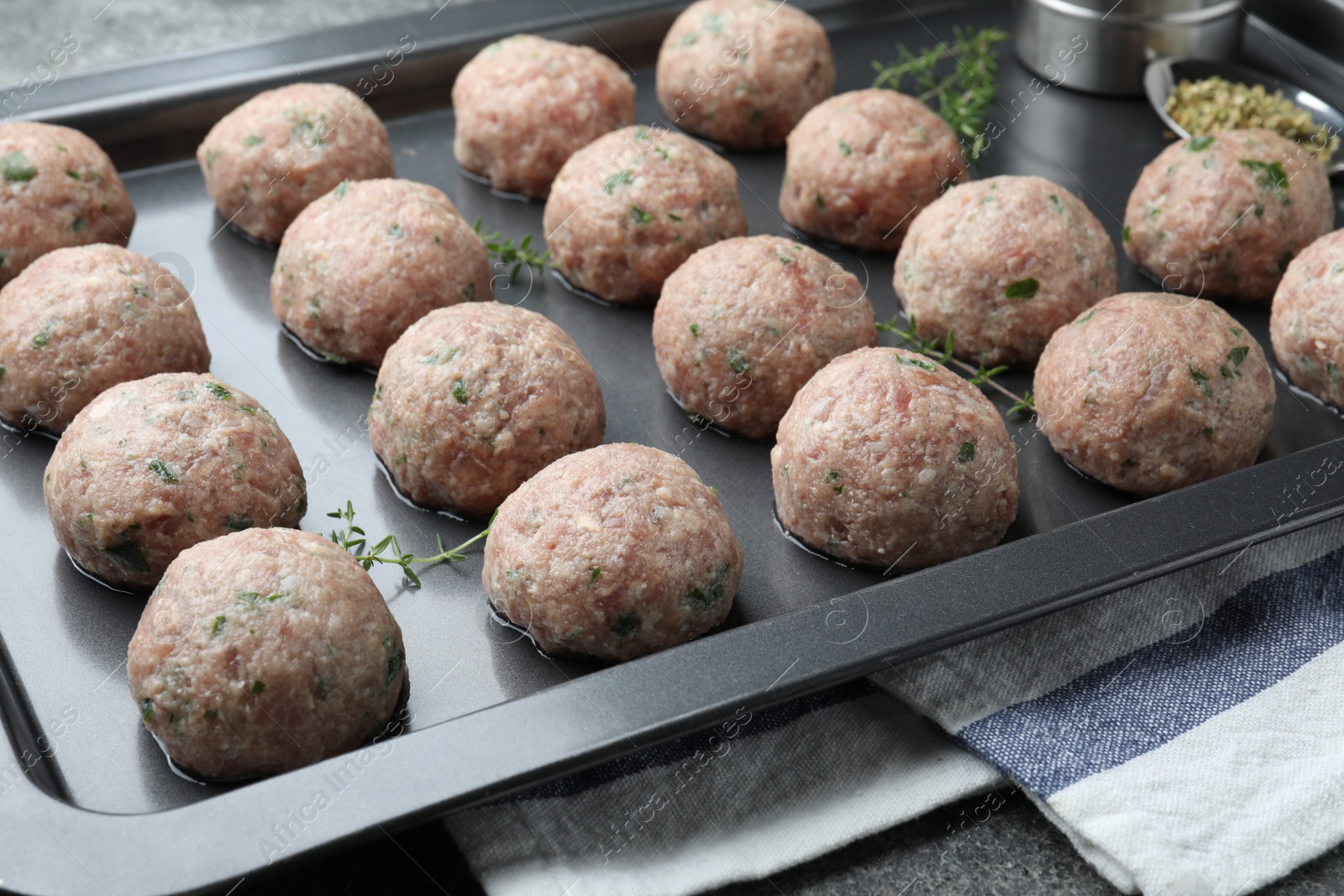 Photo of Many fresh raw meatballs in baking dish